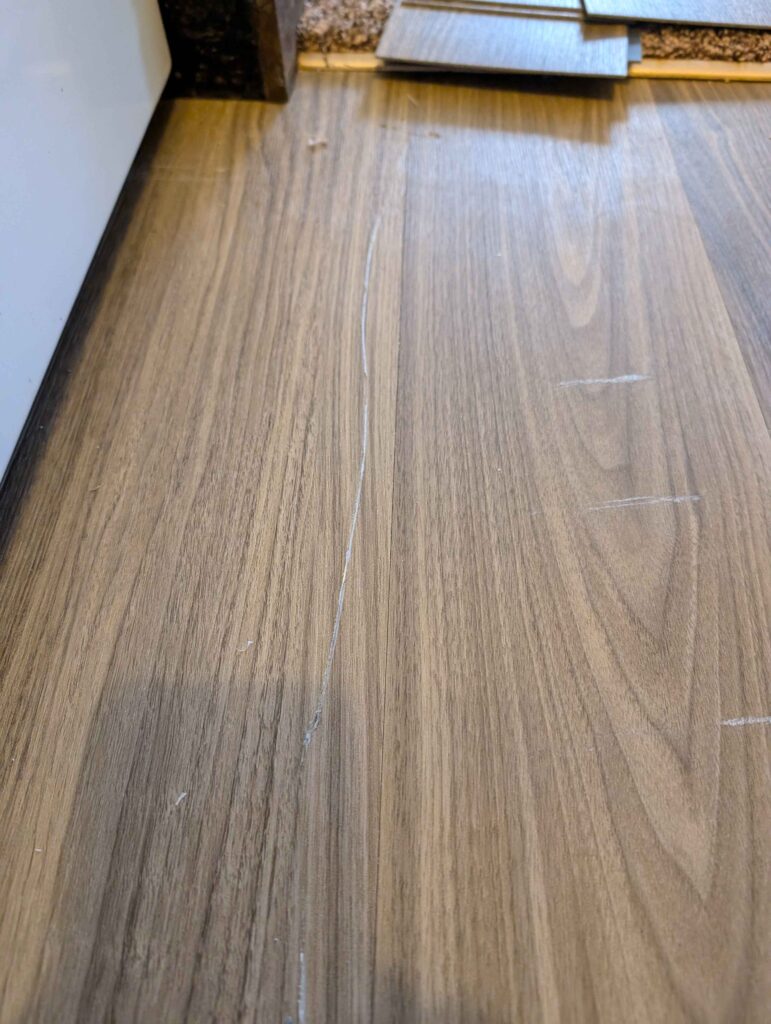 Scratched LVP — before repair